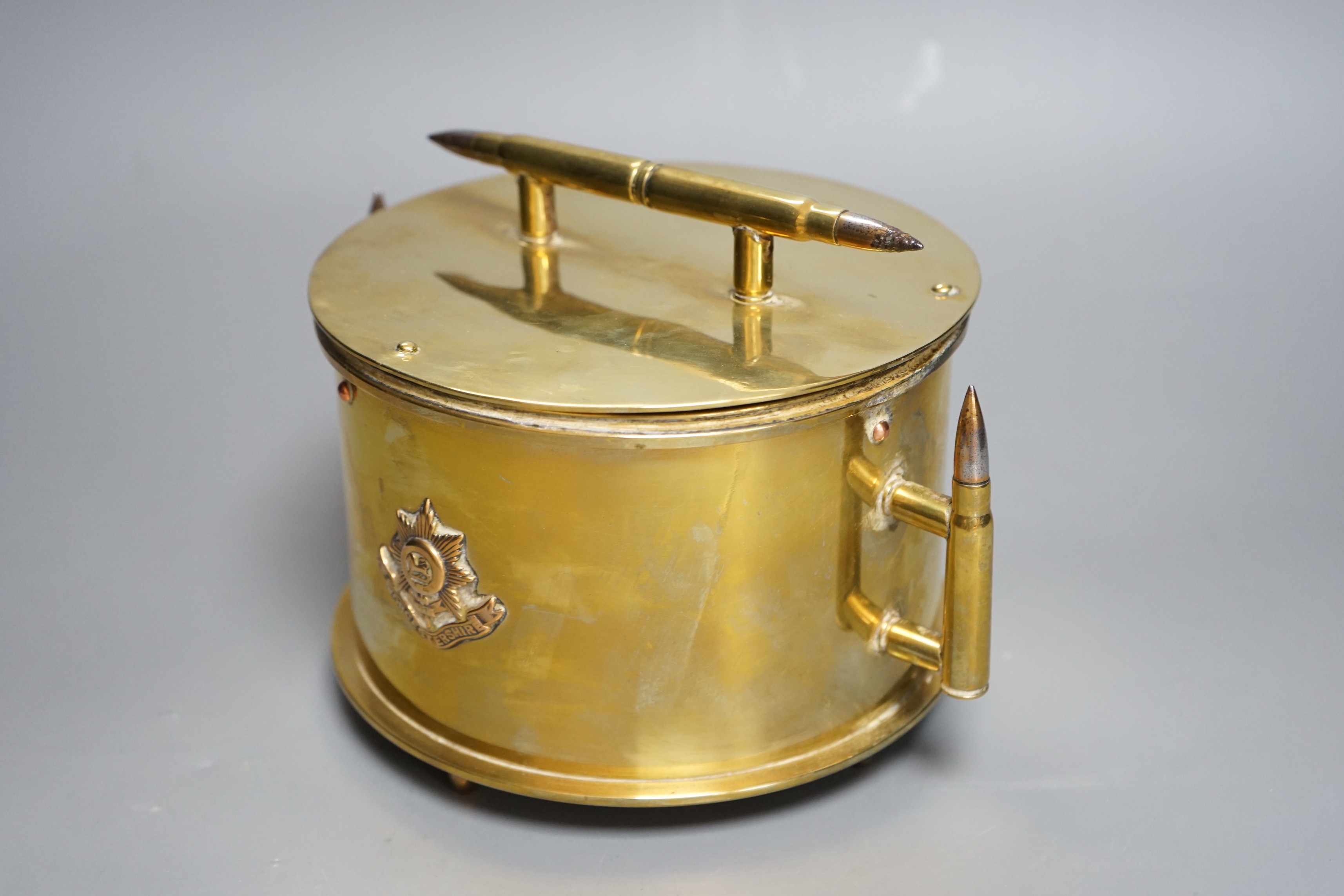 A WWI trench art biscuit barrel with applied Worcestershire regimental badge, the base dated 1918. 22cm handle to handle